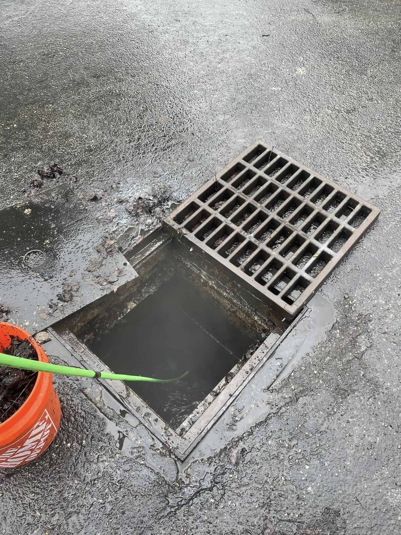 Drain Bros llc workers are installing a new drain system, with signs of recent work and cleaning visible.