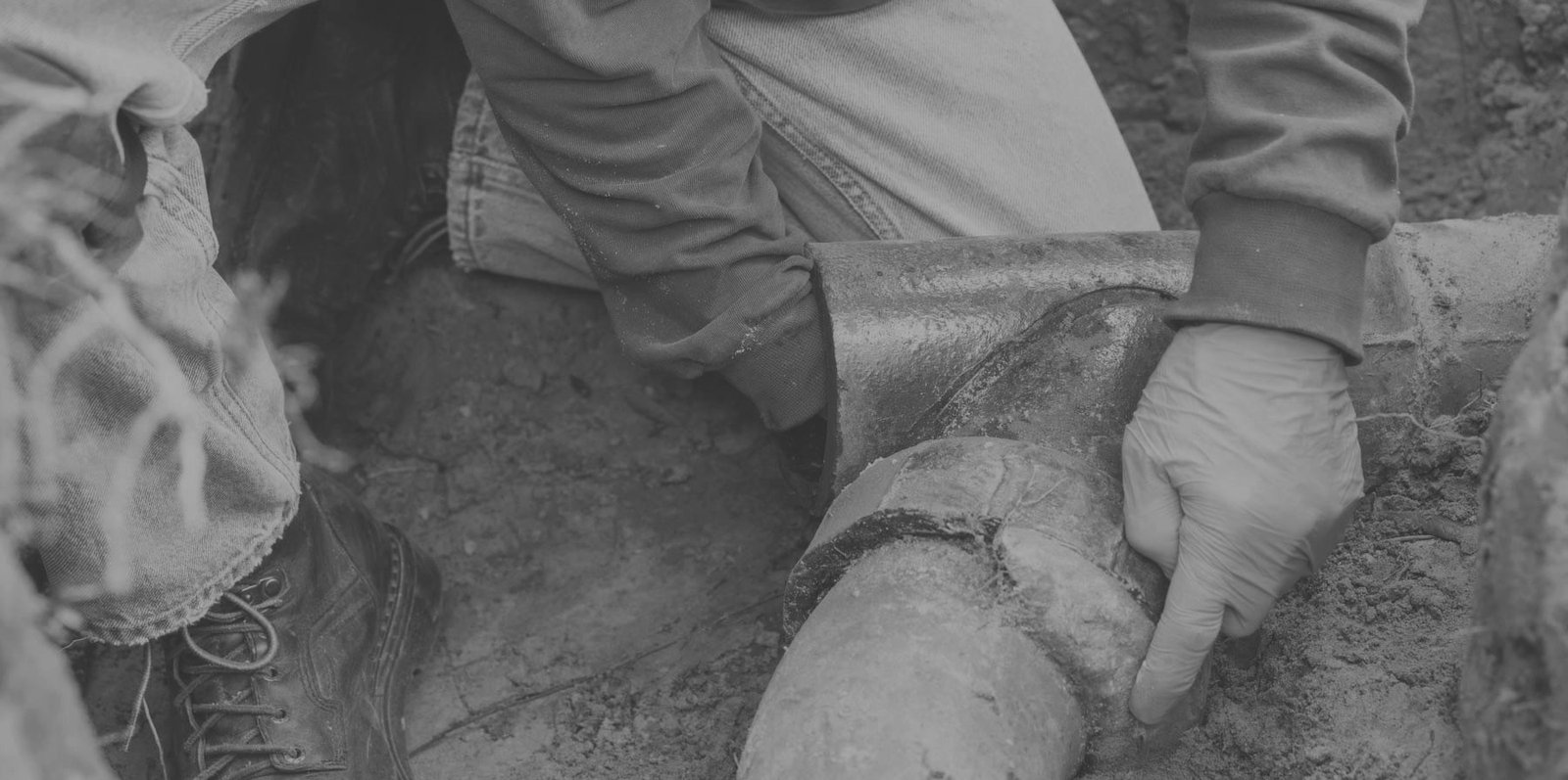 Drain Bros llc team fixing a broken outdoor pipe, showing expert help for sewer line problems.