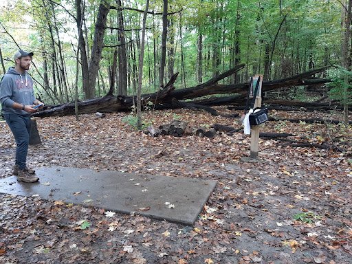 A person prepares on a project site, suggesting Drain Bros llc plans carefully for plumbing work in natural areas.