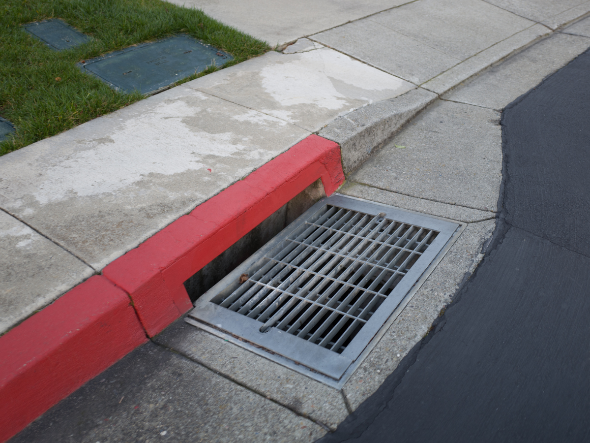 Drain Bros llc shows a proper no-parking zone by a storm drain, highlighting smart drainage area placement.