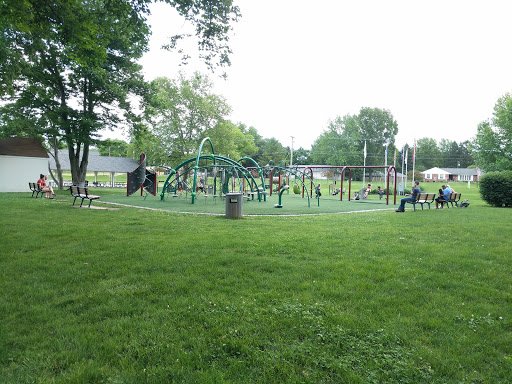 Kids play in a park as Drain Bros llc works on excavation for homes nearby, making the area better for families.