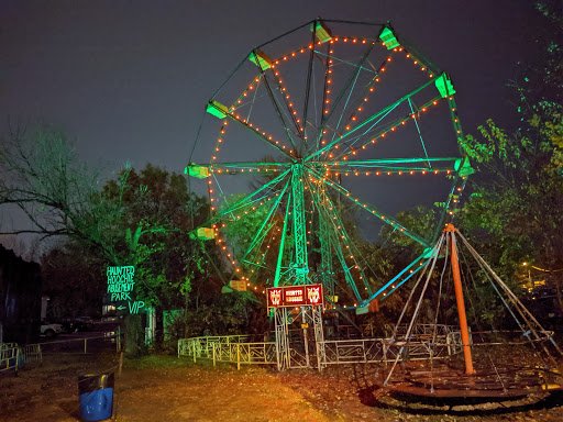 The park at night features a Ferris wheel and sign, suggesting Drain Bros llc recently did excavation work nearby.