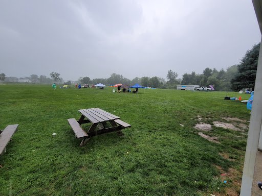 Drain Bros llc hosts a plumbing project on a rainy day, with people and tents set up in an open field.