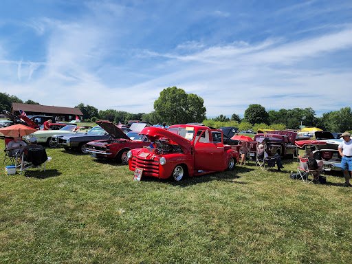 People at a car show with Drain Bros llc talk about plumbing and sewer line issues found in classic vehicles.