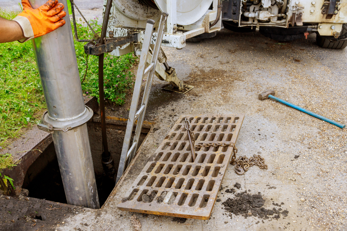 Drain Bros llc worker services a street drain, keeping water flowing safely by installing or maintaining drainage systems.