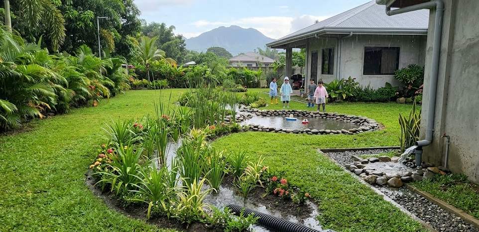 Children play in a garden, showing how Drain Bros llc keeps homes safe with proper drainage and sewer solutions.