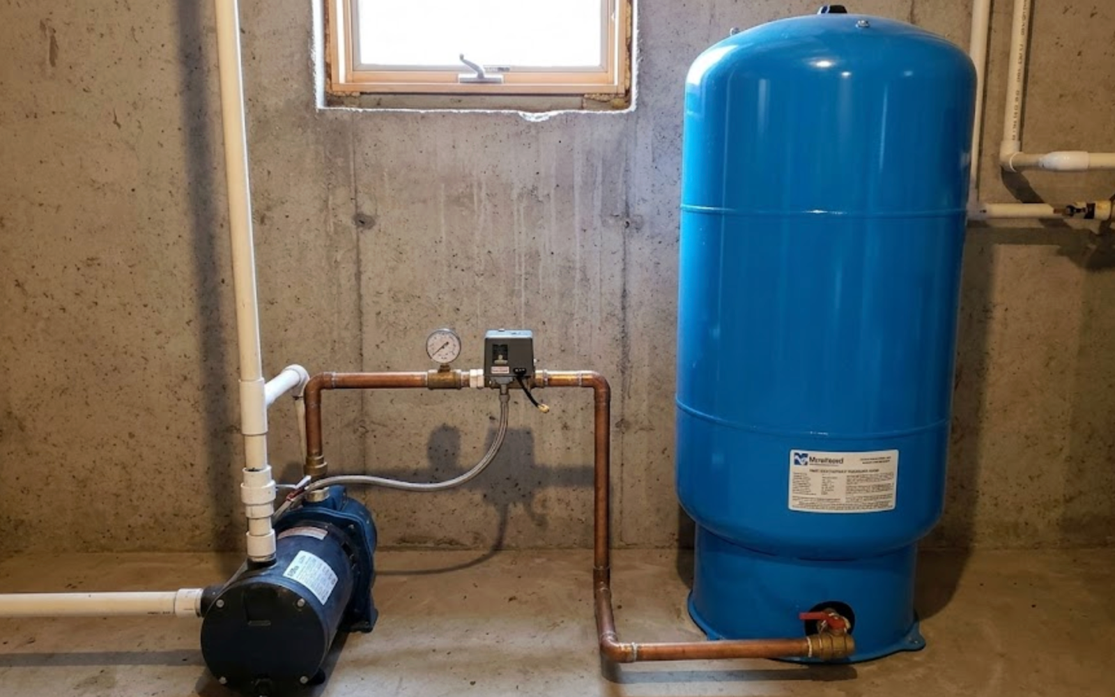 Drain Bros llc installed a reliable well water tank and pump system in a basement to provide steady household water.