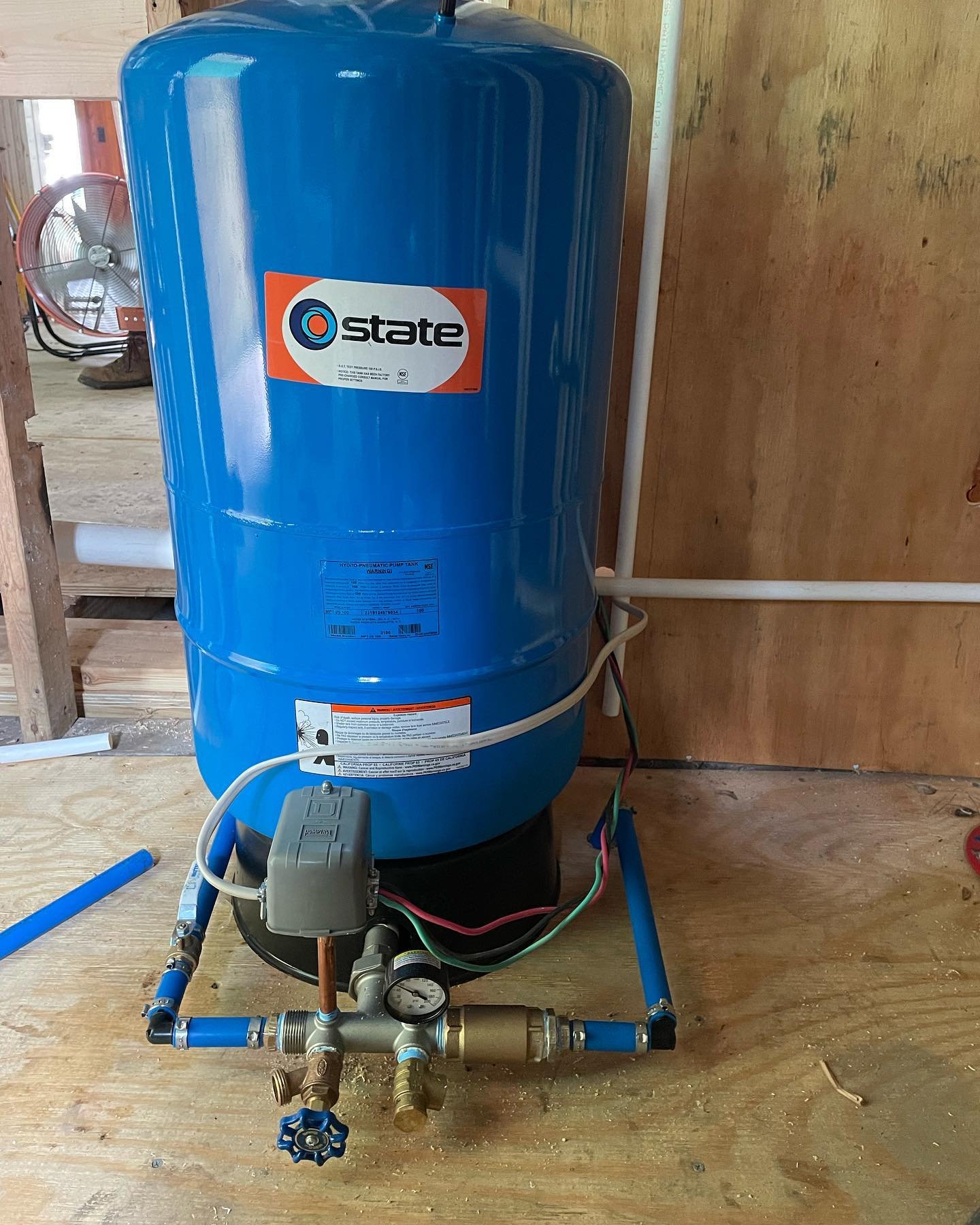 A Drain Bros llc pressure tank system in a utility room helps manage water flow for home plumbing and excavation needs.